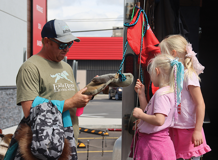 Dexter Mondor showing some children a fur mitten.